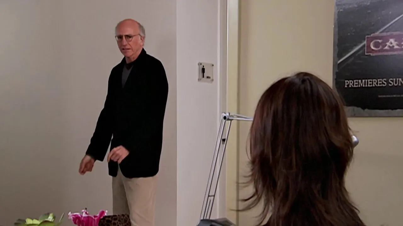 Larry David standing outside the office men's room in Curb Your Enthusiasm
