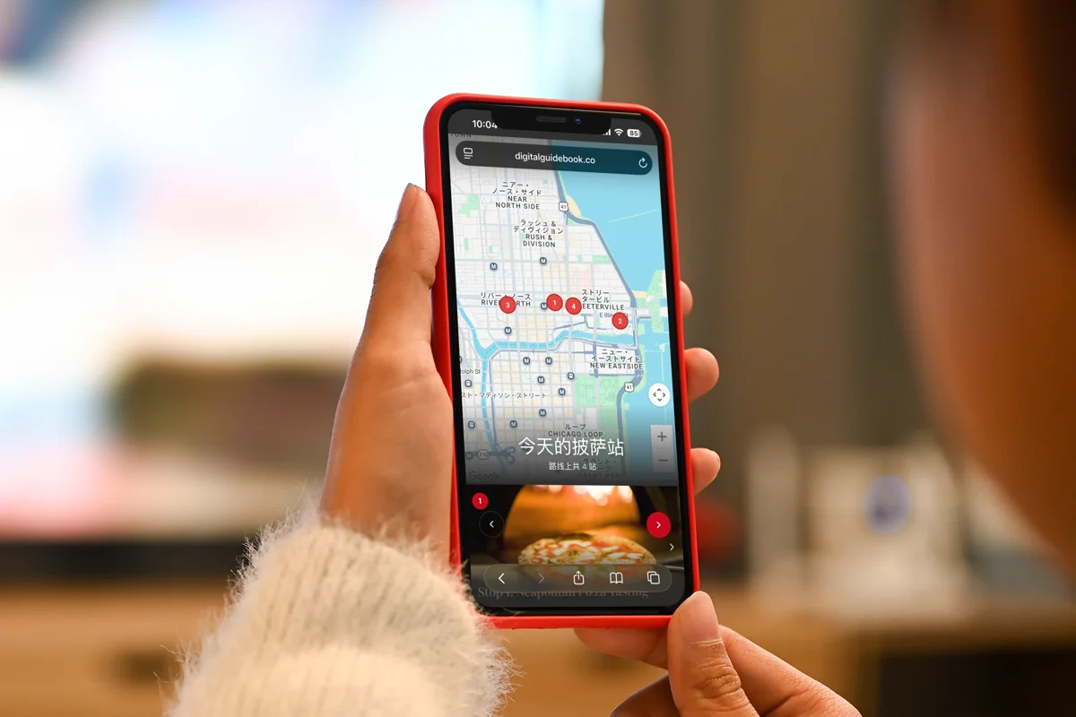 A guest looking at a guidebook map on her iPhone with the interface in Chinese, while the venue names stay in their original form