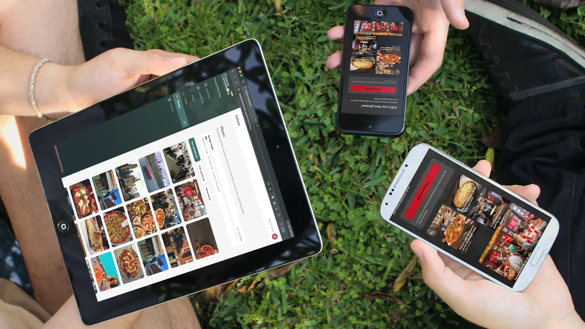 Three people sitting on the grass after a tour, one holding an iPad showing the Photos page full of guest pictures, two holding phones showing the guest photo wall